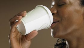 Mature woman drinking from disposable cup, close-up