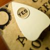 Planchette on talking board highlighting word yes, close-up (differential focus)