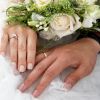 Close-Up Of Newlywed Couple Holding Rose Bouquet