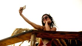 Beautiful young woman doing selfie on the beach