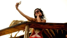 Beautiful young woman doing selfie on the beach