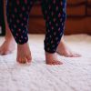 Low Section Of Mother And Baby Girl Walking On Rug At Home