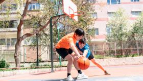 Young asian male adults playing basketball outdoors