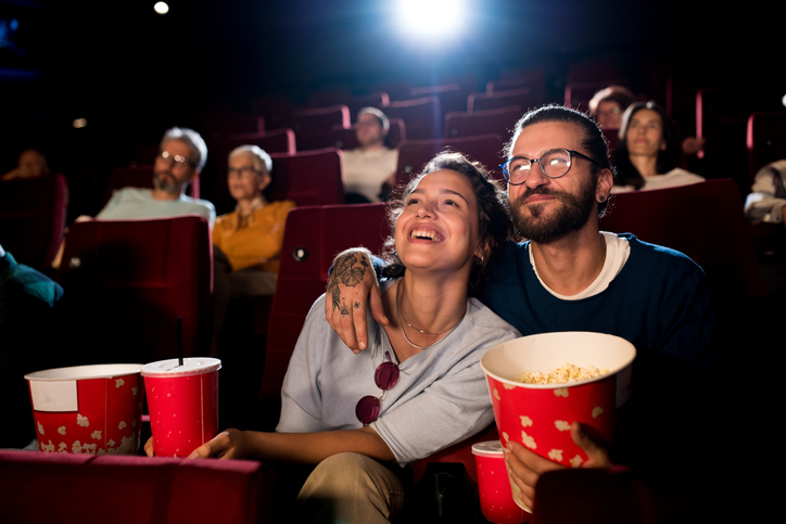 Young couple enjoying a fun movie at the cinema